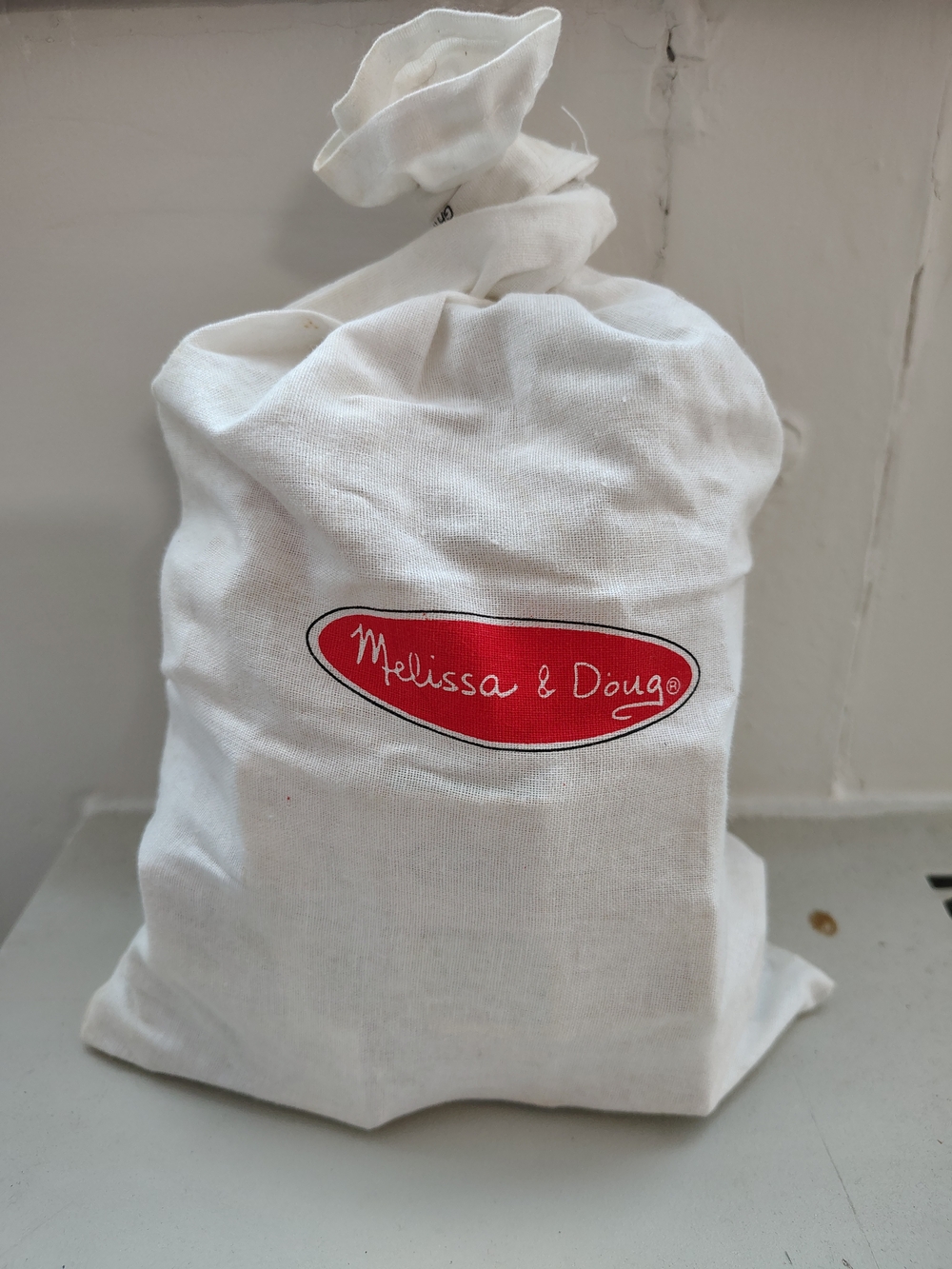 Melissa & Doug White Canvas Drawstring Bag with Red Logo and Wooden Blocks